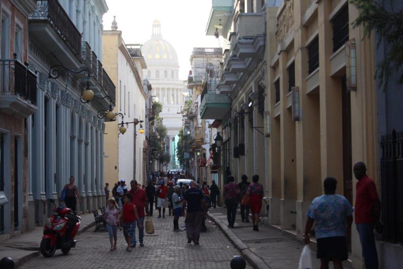 Paisaje de una calle estrecha de La Habana con El Capitolio Nacional de fondo. 