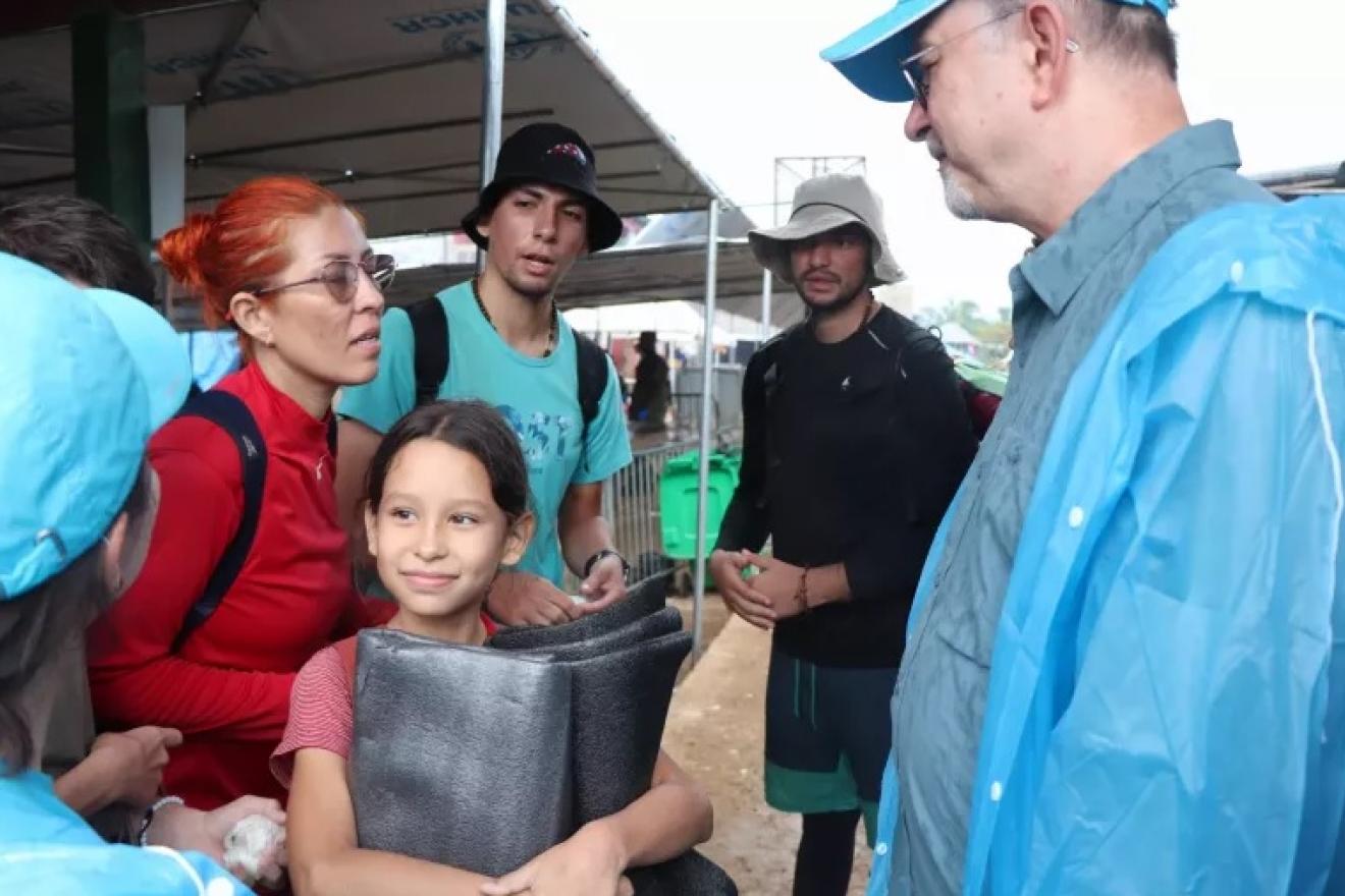 Varios cargos de UNICEF conversan con familias de migrantes con niños que llegan a Bajo Chiquito (Panamá) en el Tapón del Darién.