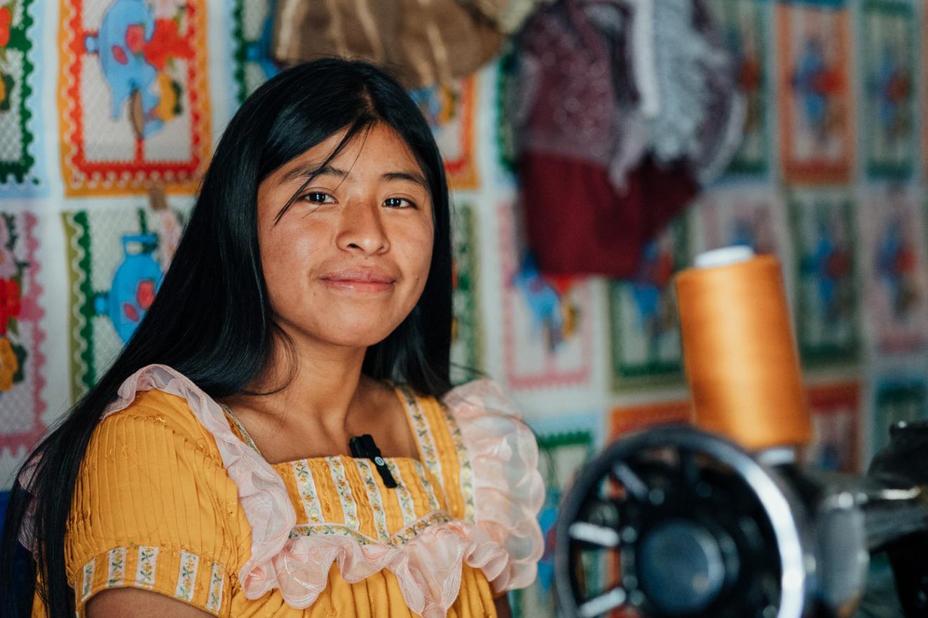 Una joven sentada junto a una máquina de costura