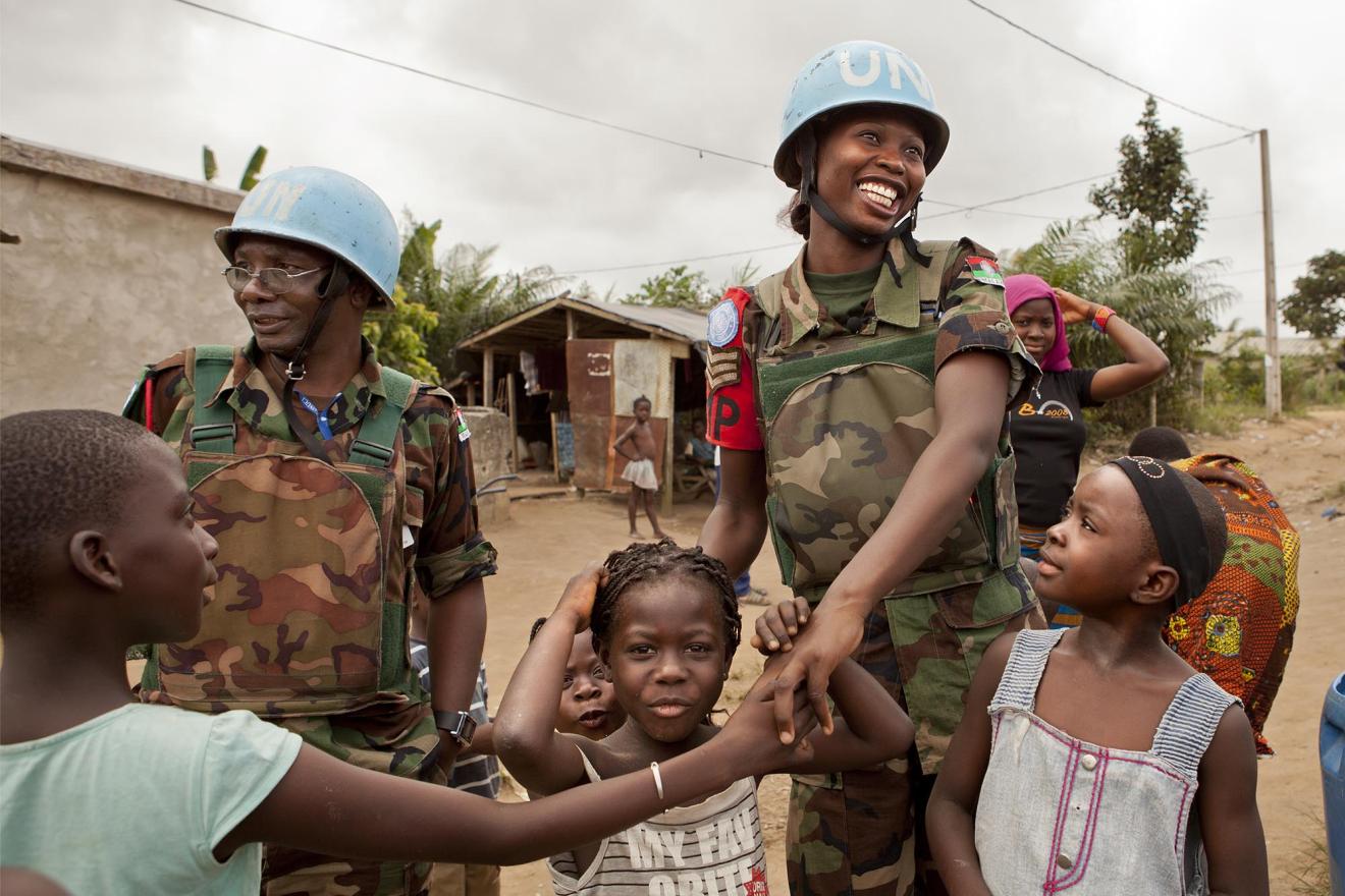 Des soldats de la paix malawiens des Nations Unies saluent des enfants lors d'une patrouille en Côte d'Ivoire.