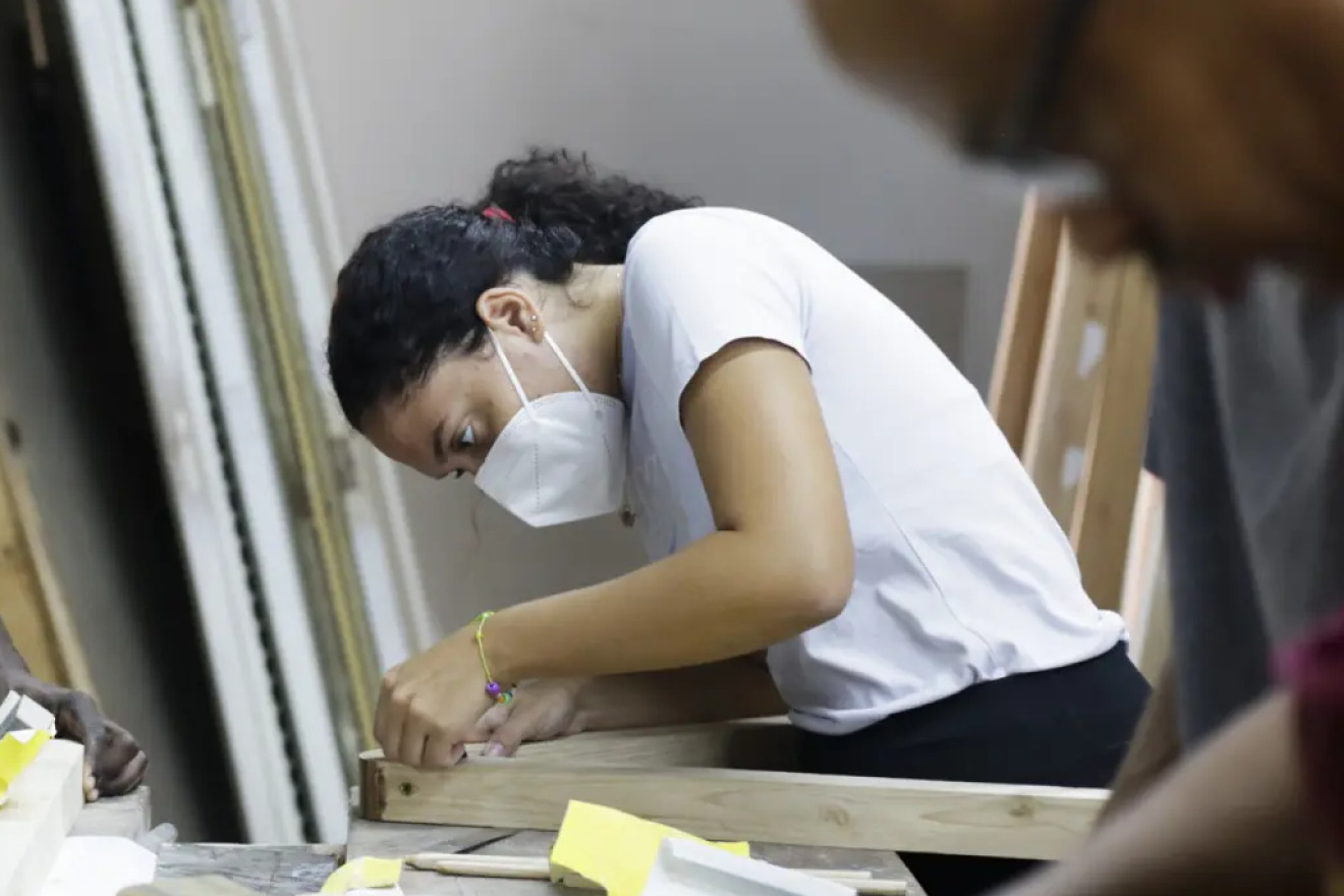 A lady working on wood. 