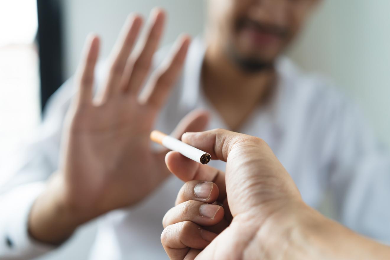 Gros plan sur les mains d'une personne qui refuse d'accepter une cigarette.