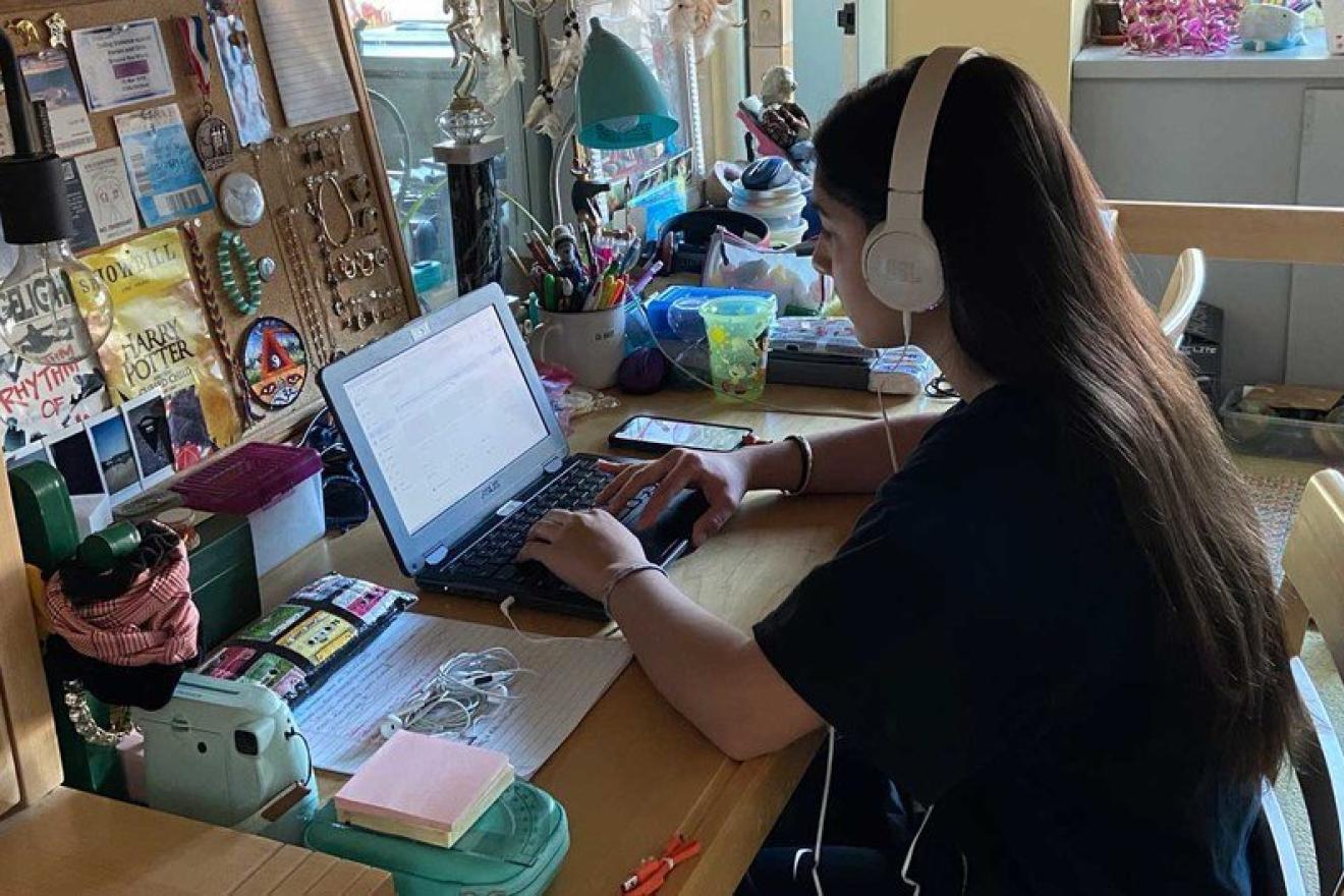 Una joven estudiando por internet en casa.