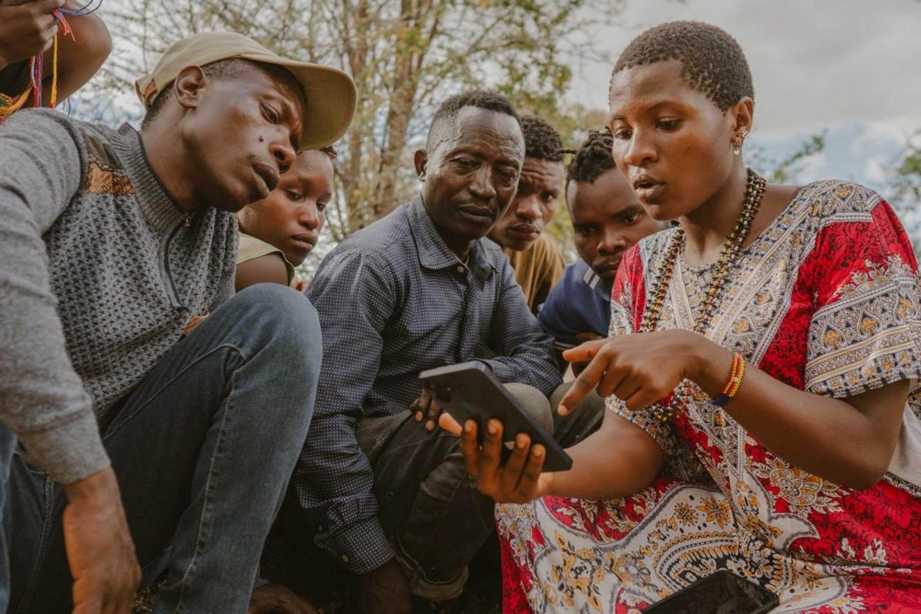A woman shows a group of people how the Cybertracker application works