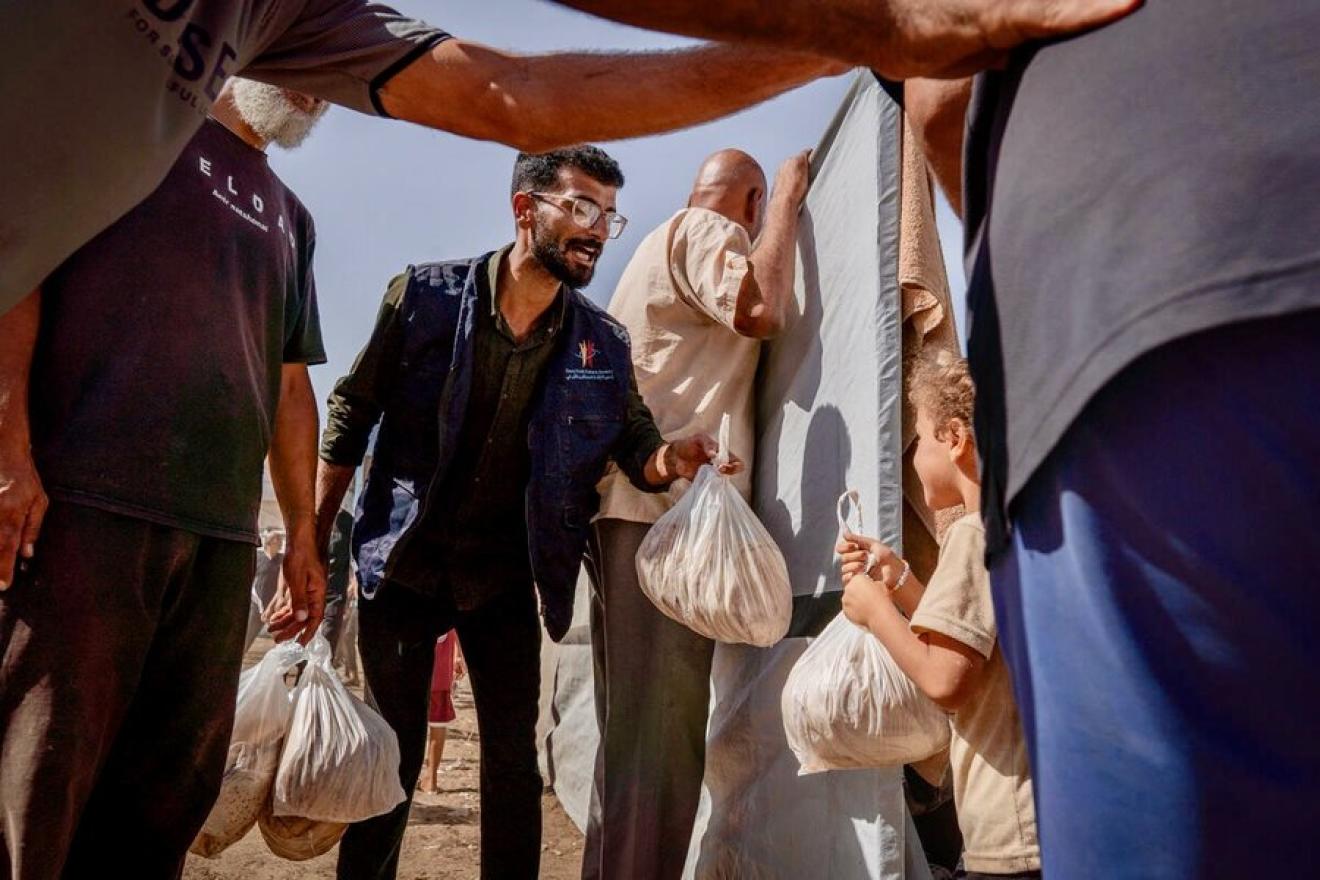 WFP worker distributing bags of flatbread