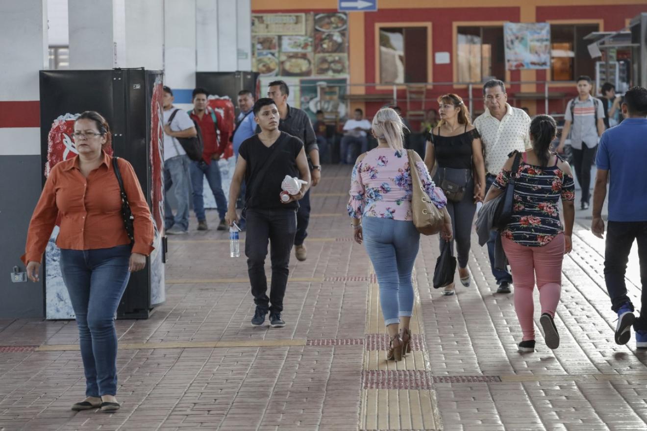 Varias personas caminan por la calle. 