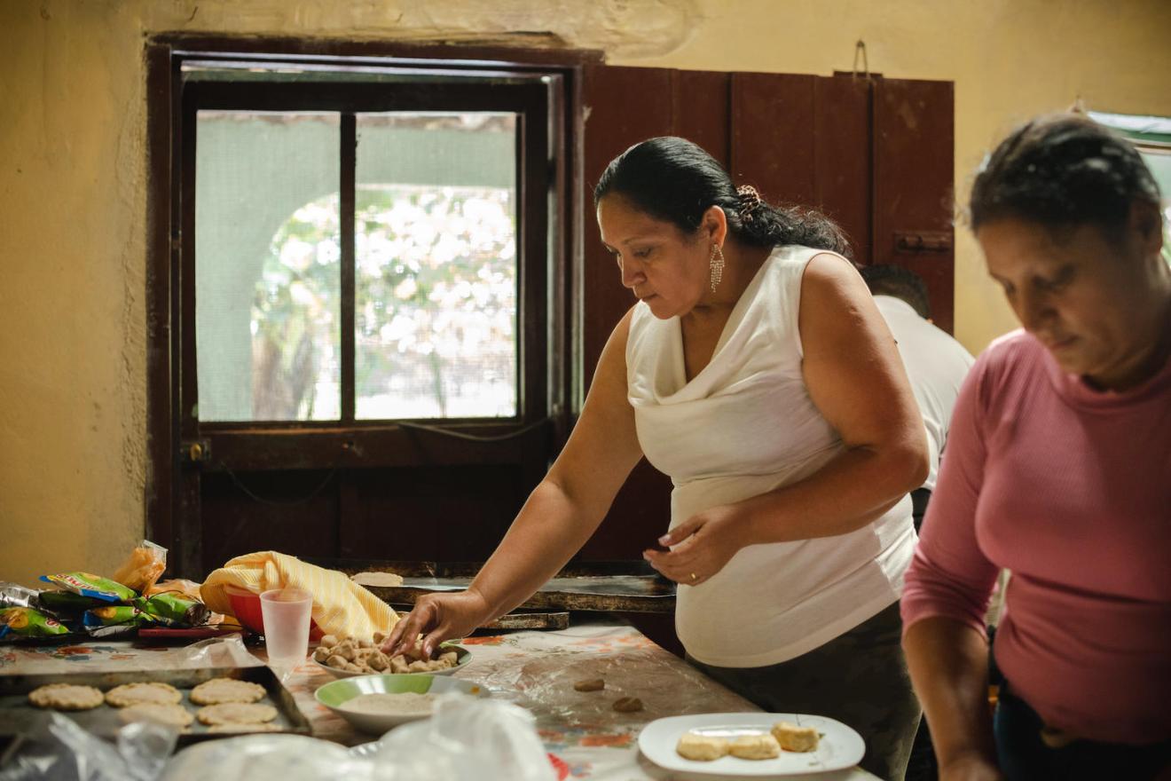 Dos mujeres preparan comida en una cocina. 
