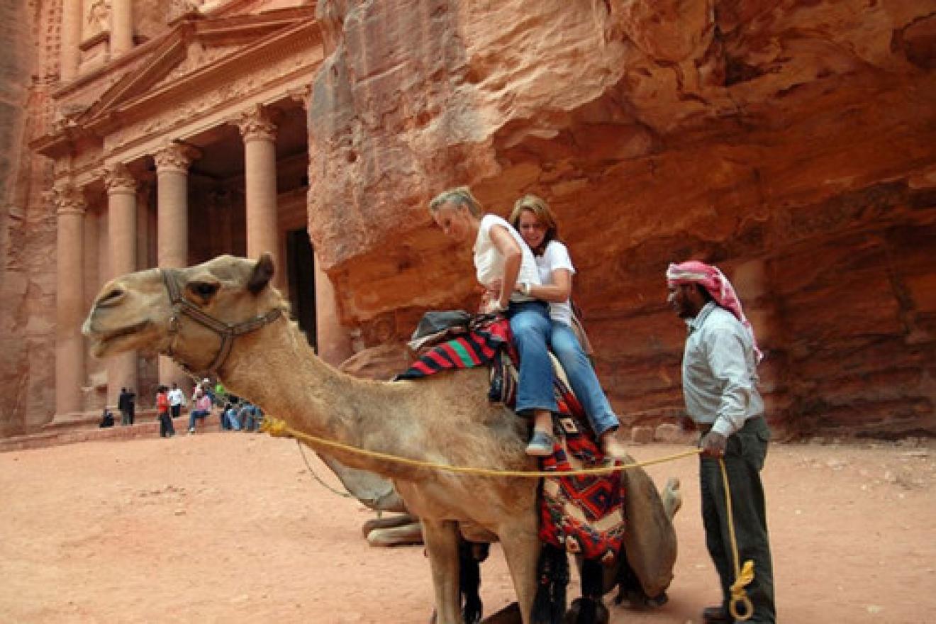 Turistas subiéndose a un camello en Petra, en Jordania. Turistas subiéndose a un camello en Petra, en Jordania.