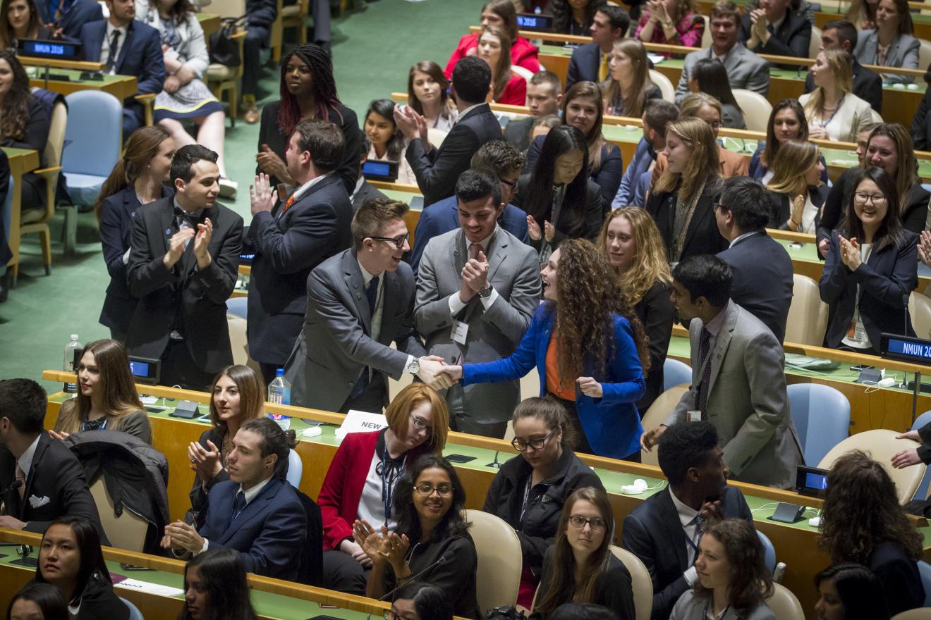 Students in the U.N. chambers speaking to each other.