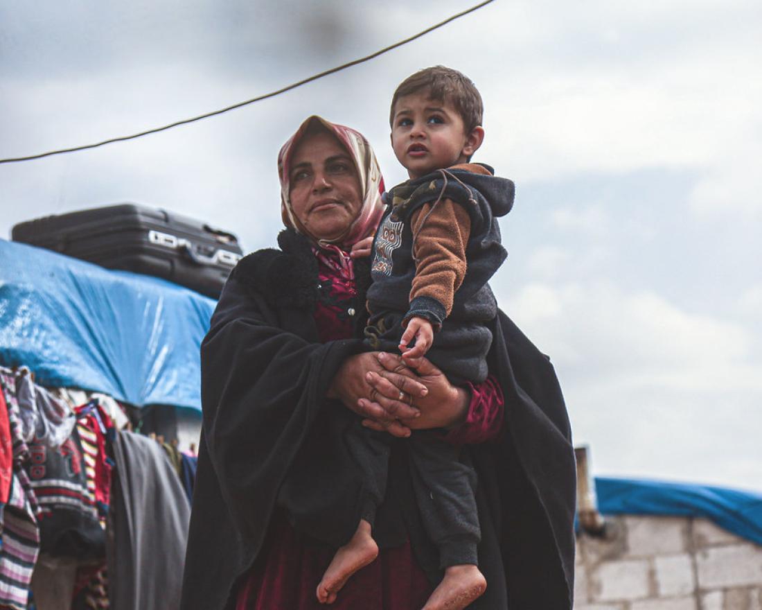 A widow holds her grandson in a displaced persons camp in northern Idlib Governorate, Syria.