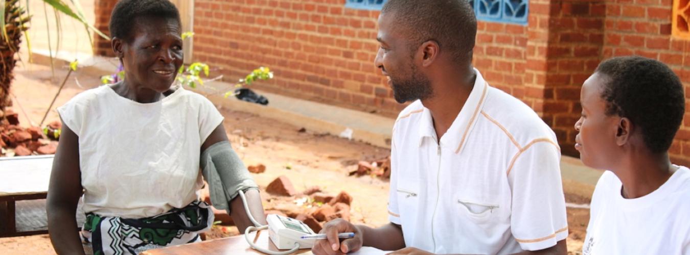 Unos sanitarios toman la presión arterial a una señora en Malawi (2016).