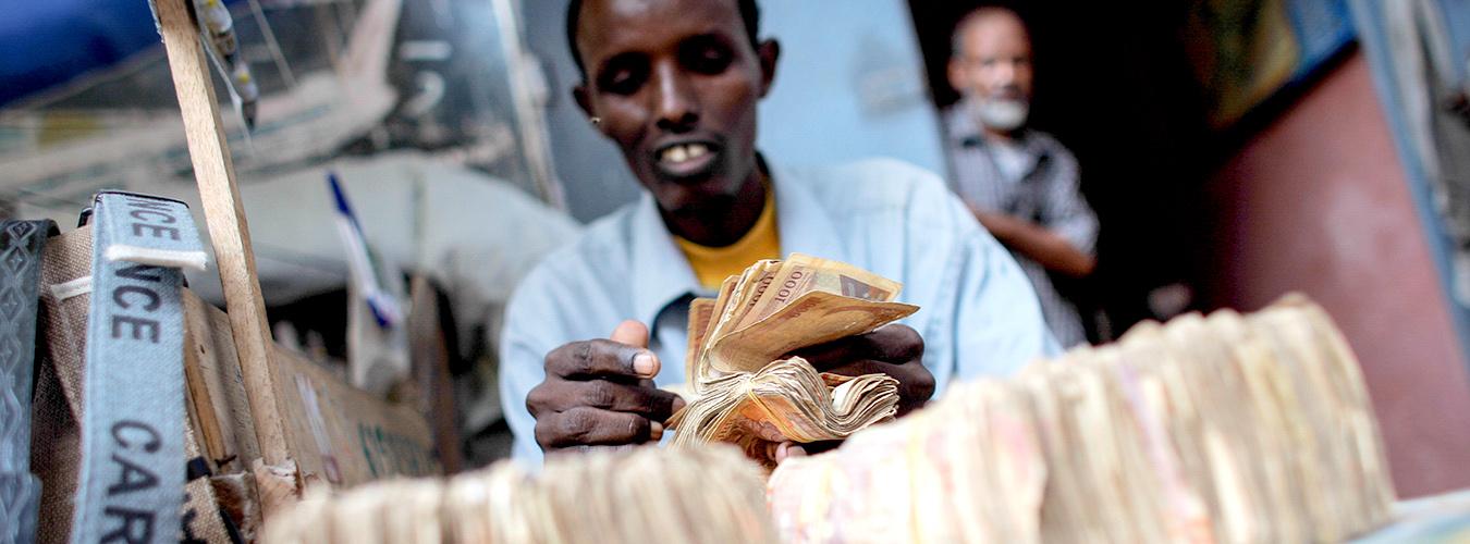 Un homme compte des billets de banque dans un bureau de change.