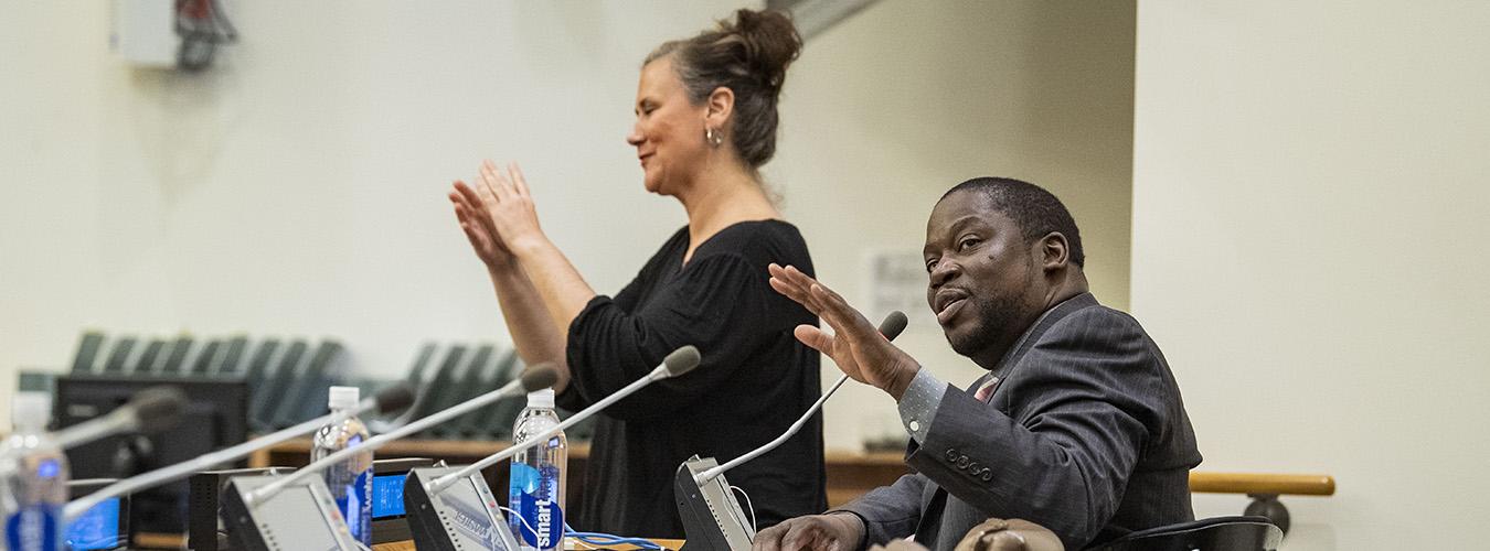 El actor Daryl Mitchell (sentado) interviene en el evento "El arte de lo posible", celebrado con motivo del Día Internacional de las Personas con Discapacidad; junto a él, una intérprete de lenguaje de señas. 