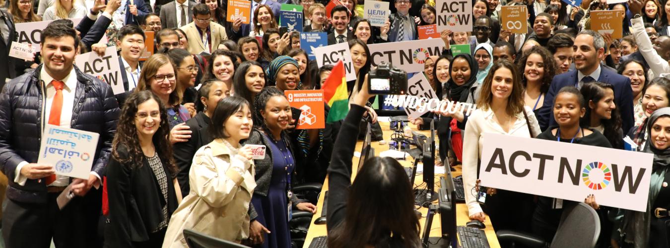 联合国青年论坛的参与者举着支持“即刻行动”运动的标志。
