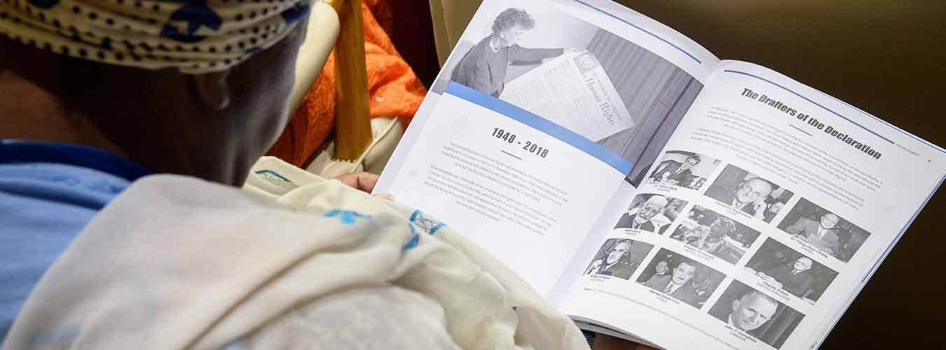 A participant examines a pamphlet at the 15th Annual International Human Rights Summit 2018, which focused on Youth for Human Rights.