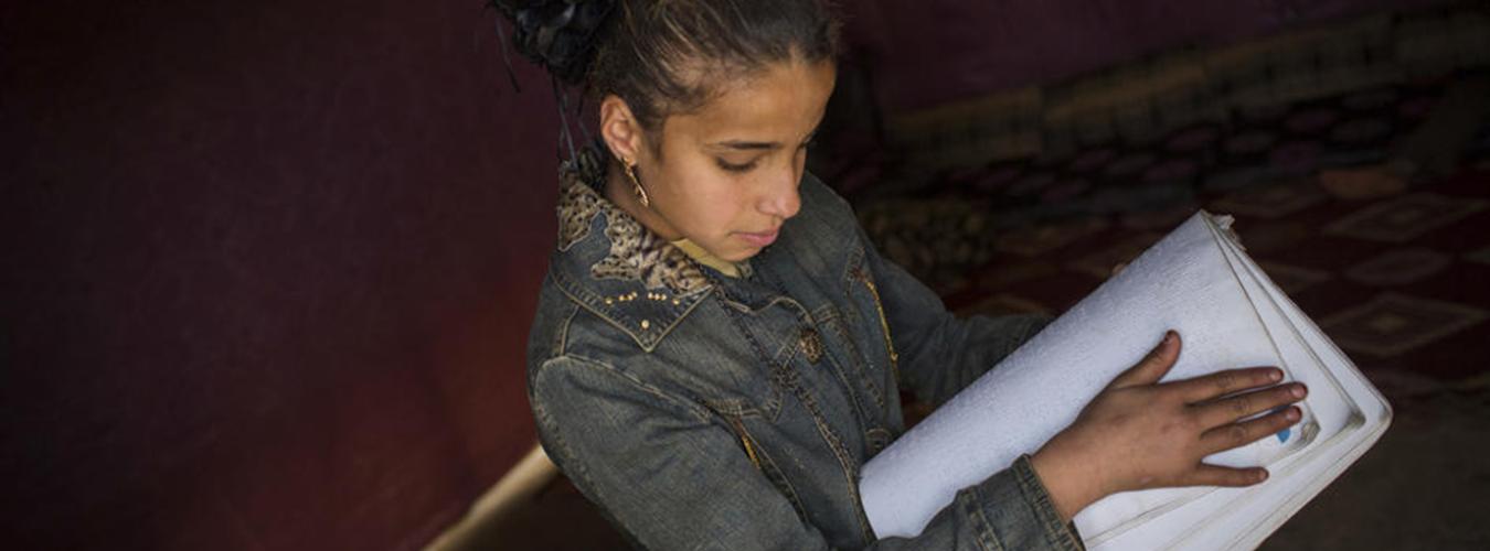 Une fillette en train de lire du braille dans dans un camp de réfugiés syriens au Liban.e la Bekaa (Liban, 2014).