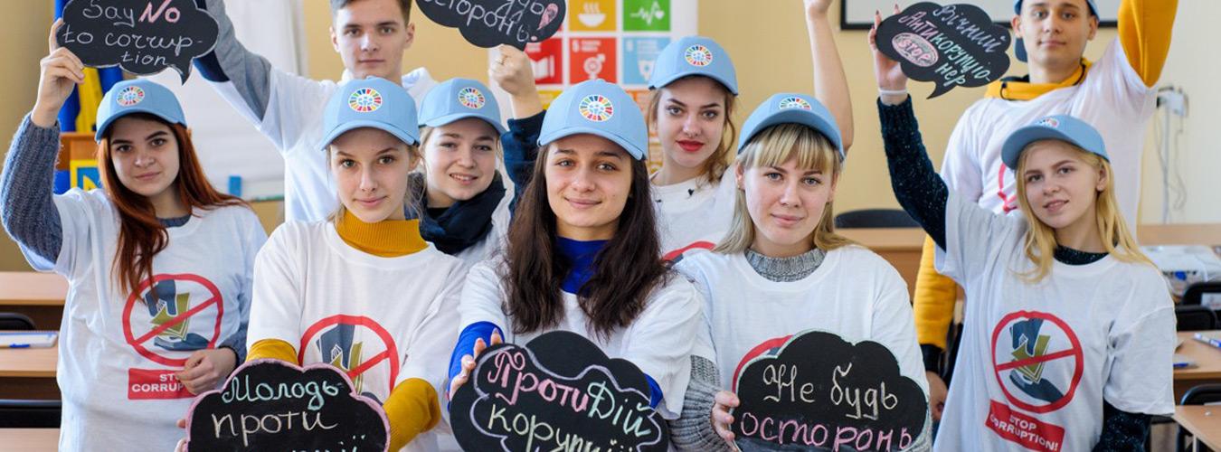 Un groupe de jeunes montrant des pancartes "Non à la corruption".