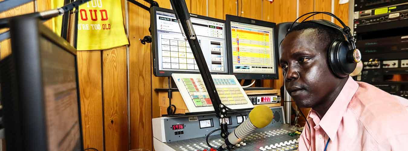 A man speaks into a microphone in a radio studio in Juba, South Sudan.