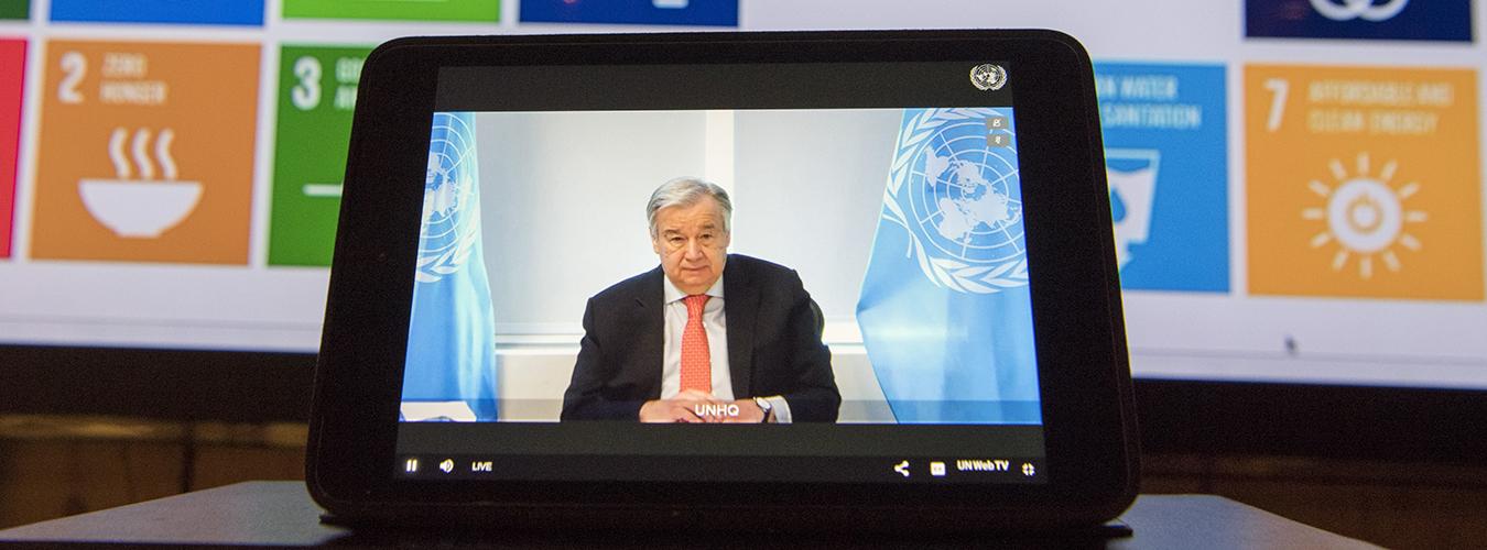 El Secretario General António Guterres en una pantalla con un fondo con los iconos de los Objetivos de Desarrollo Sostenible. 