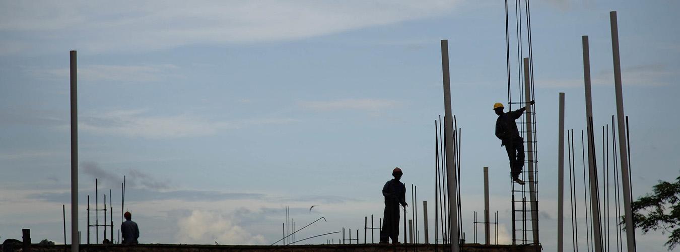 Silhouettes d'ouvriers sur un chantier de construction.