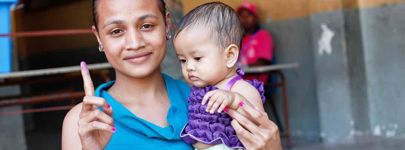 Une femme montre l’encre qu’elle a sur le doigt, preuve qu’elle a voté lors des élections législatives au Timor-Leste, le 7 juillet 2012. Photo ONU / Martine Perret