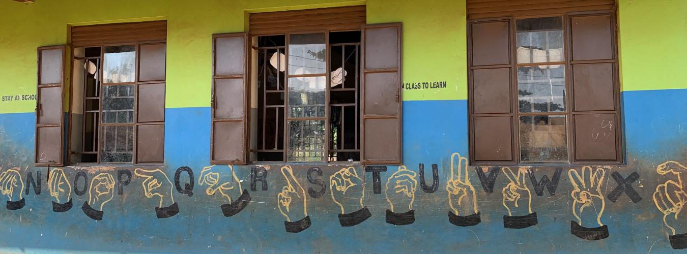 Классная комната в школе Камураси, Уганда, с нарисованным на стене алфавитом угандийского языка жестов.