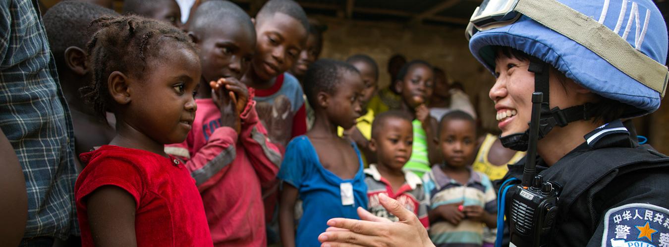 A member of UNMIL Peacekeeper interacts with children.