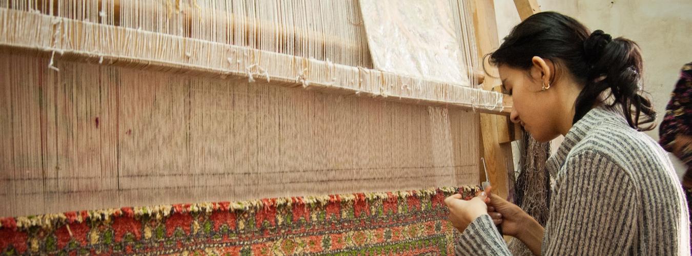 weaver in front of a loom