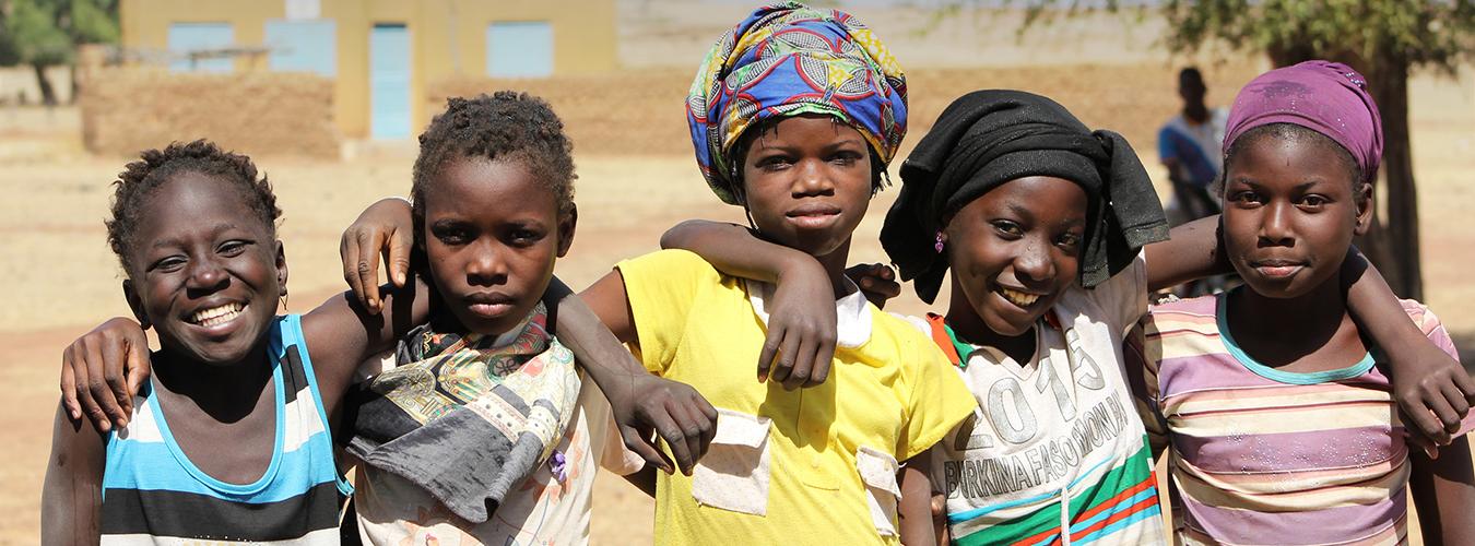 Primer plano de unas niñas de unos 10 años mirando a cámara, en Burkina Faso.