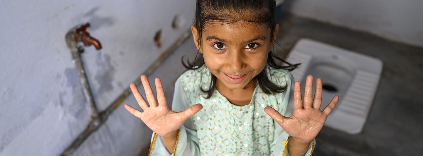 Четырехлетняя Соня демонстрирует свои чистые руки после посещения туалета.