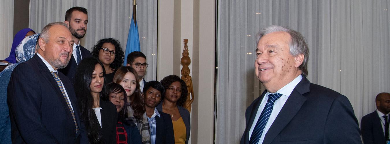 Una foto del Secretario General de las Naciones Unidas, Antonio Guterres, saludando a unos jóvenes.