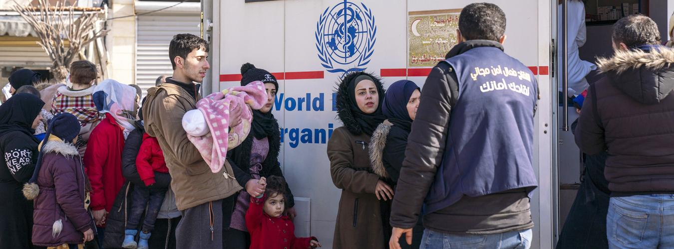 سوريون في طابور أمام عيادة متنقلة تابعة لمنظمة الصحة العالمية