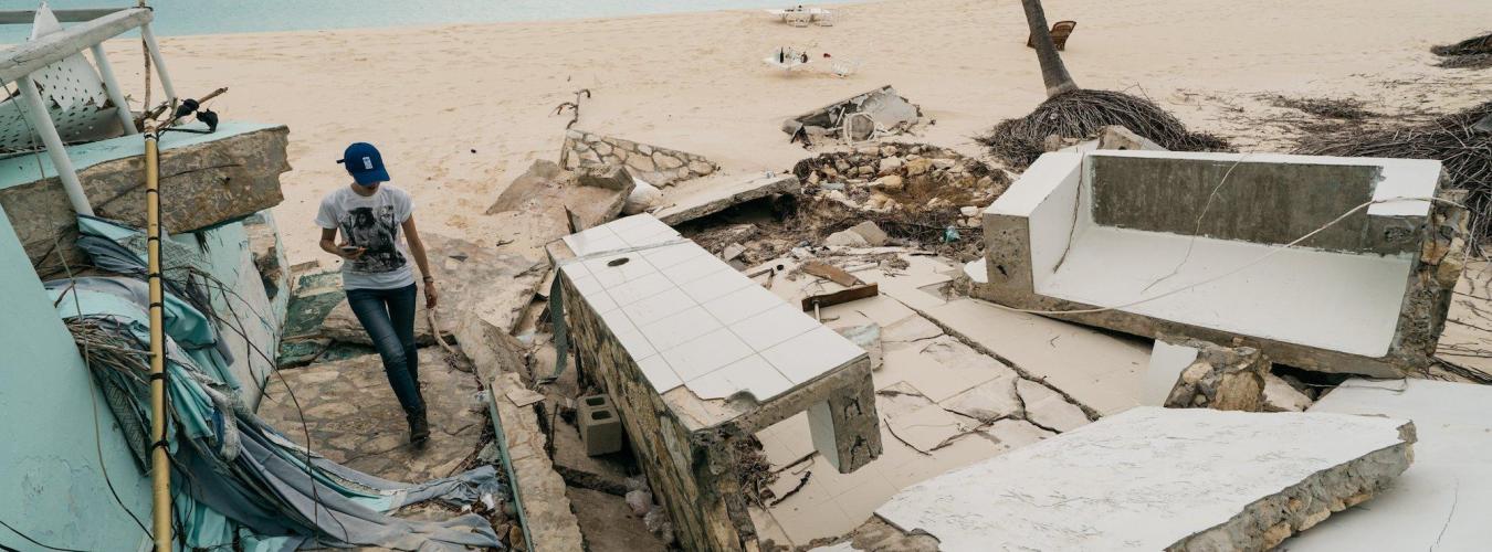 Une femme marchant parmi les débris après le passage de l'ouragan Irma.