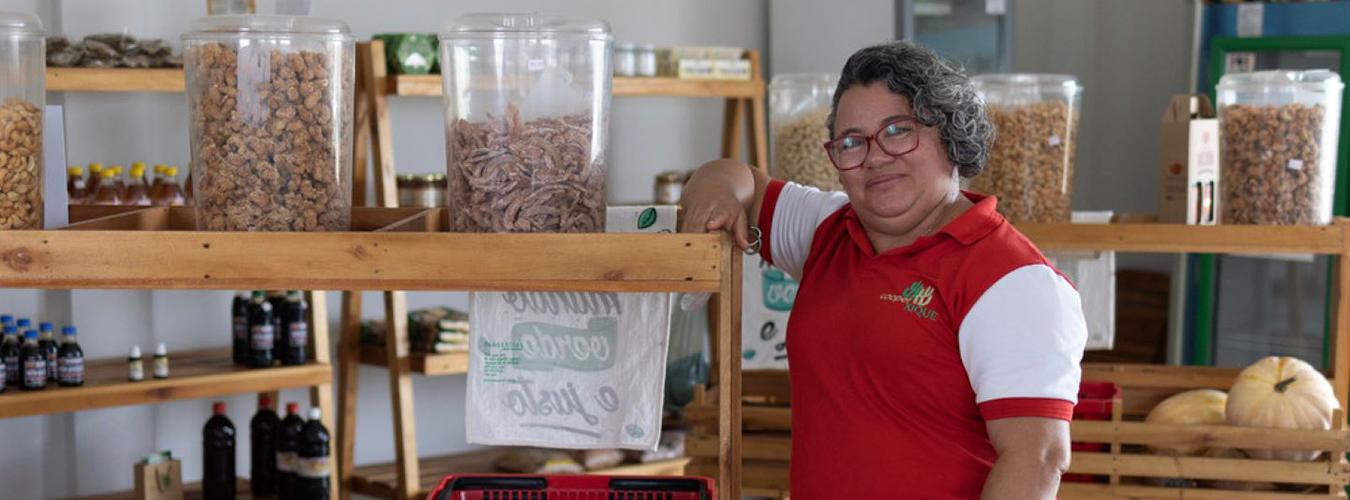 smiling woman among shelves of agricultural goods