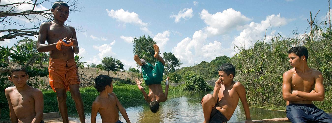 مجموعة من المراهقين يناظرون رفقيا لهم يقفز إلى نهر.