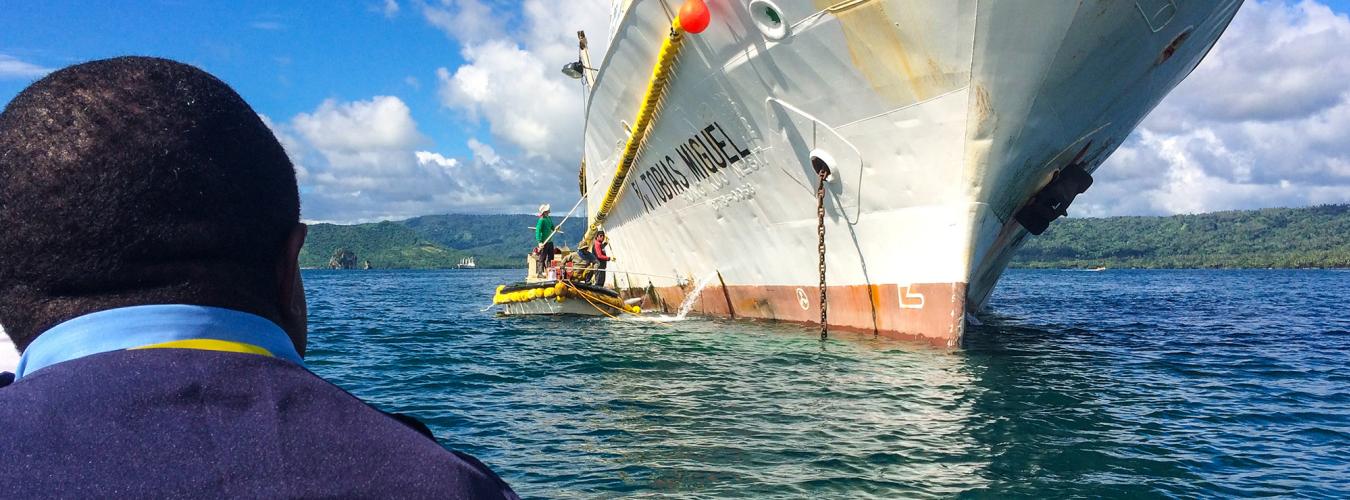 Un homme sur un bateau approche un navire de pêche