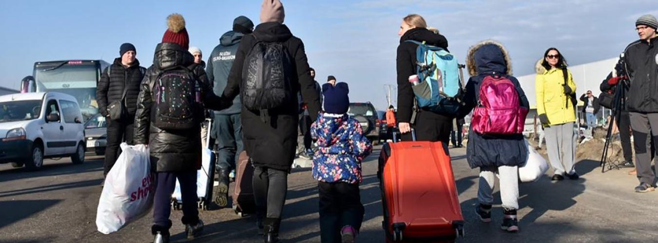 Des familles en marche, portant des valises et des sacs