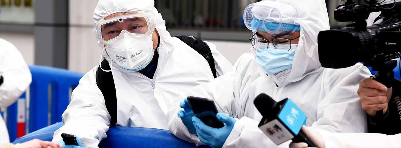 Des journalistes à la sortie d'un hôpital mobile à Wuhan, en Chine centrale, l'épicentre initial de l'épidémie de COVID-19.