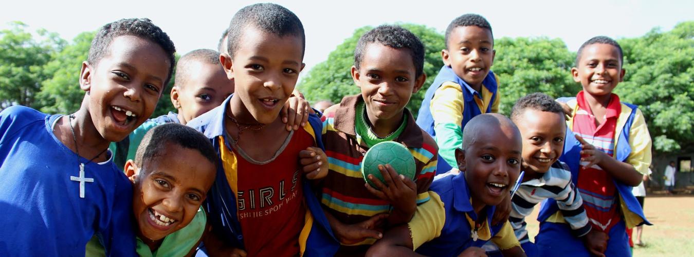 Un groupe de jeunes enfants sourient face à la caméra