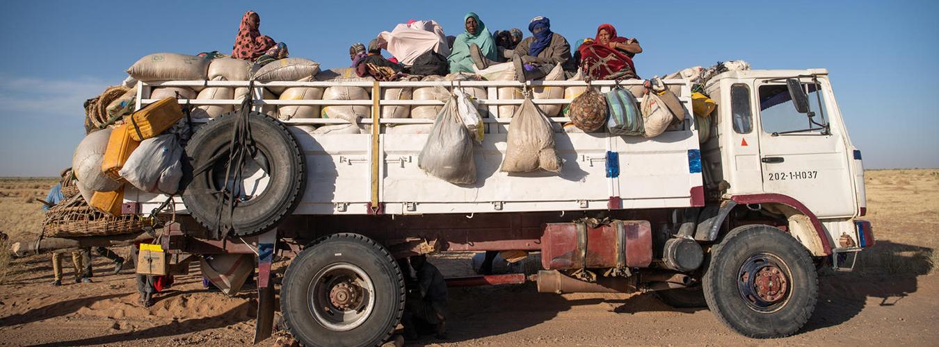 Des migrants voyagent à l'arrière d'un camion. 