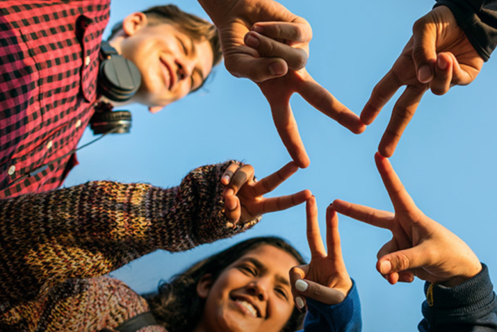 Des enfants font le signe de l'étoile avec leurs mains