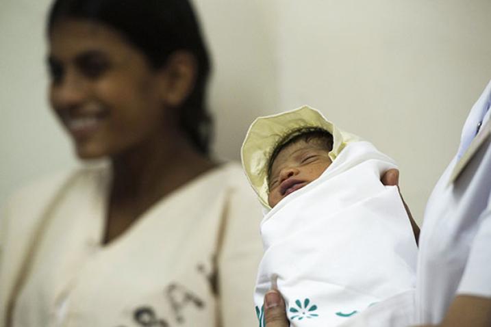 A nurse holds a newborn child at Cama Hospital, a major hospital for women and children in Mumbai, India.