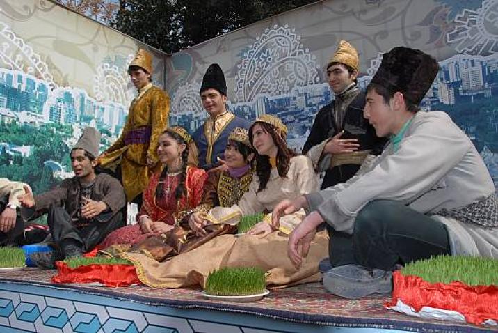 young people in traditional dress sitting down on stage