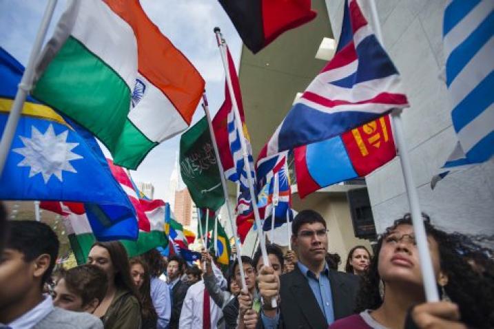 Молодые люди с флагами государств-членов во время церемонии в штаб-квартире ООН.