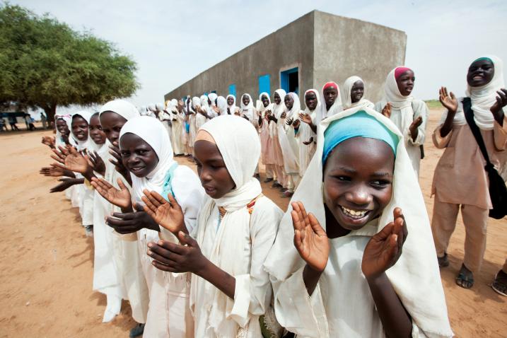 Young girls clapping their hands in front of a school in North Darfur, celebrating the opening of a new clinic