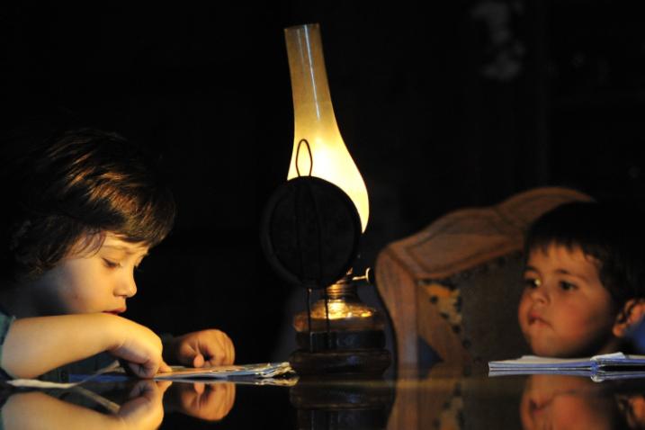 enfants étudiant à la lumière d'une lampe à gaz