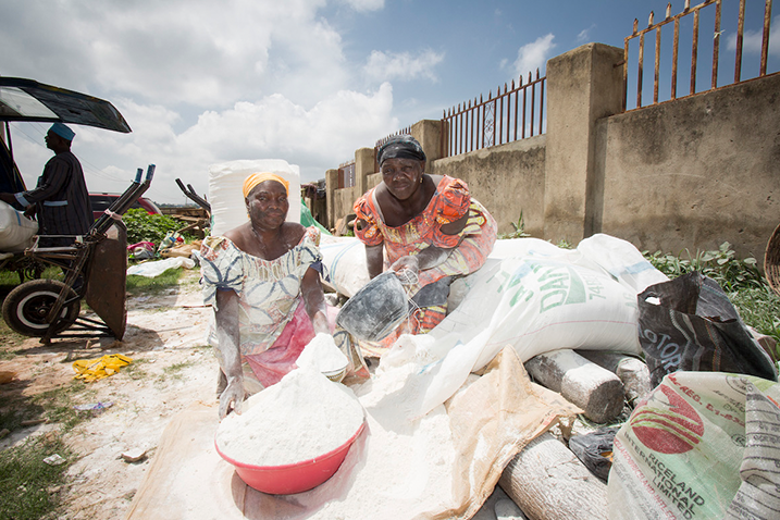 Deux femmes présentent leur stock de farine de manioc sur un étalage de marché