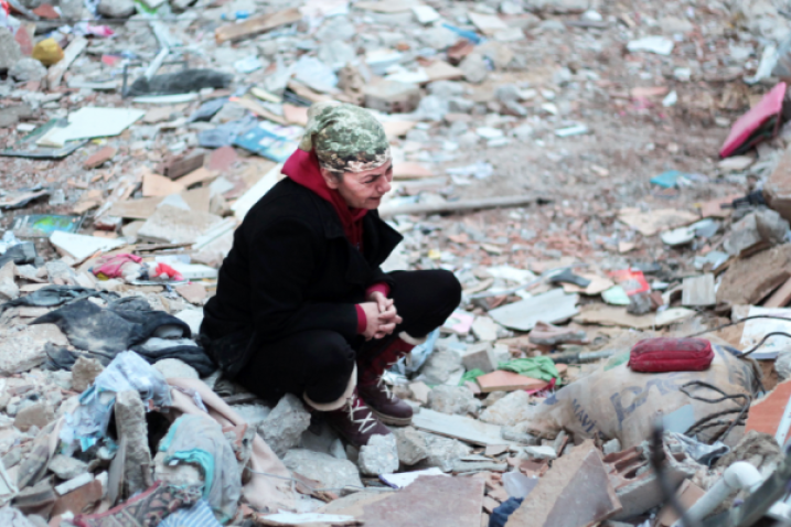 woman crying among earthquake rubble