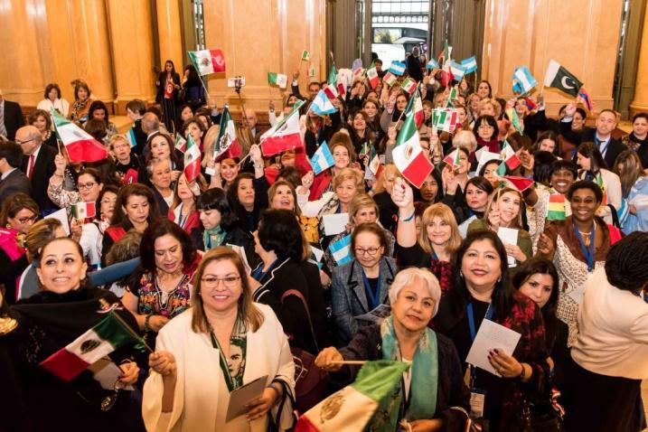 Group of women demonstrating in a hall with flags from different countries