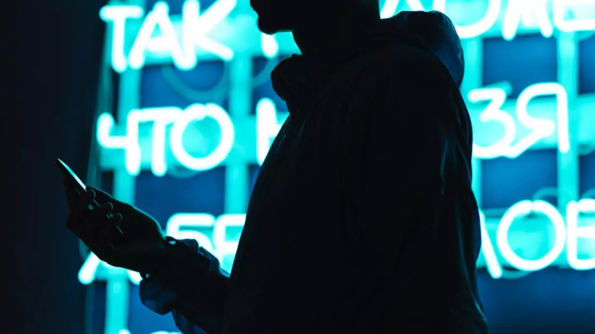 Silhouette d'une personne tenant un téléphone portable